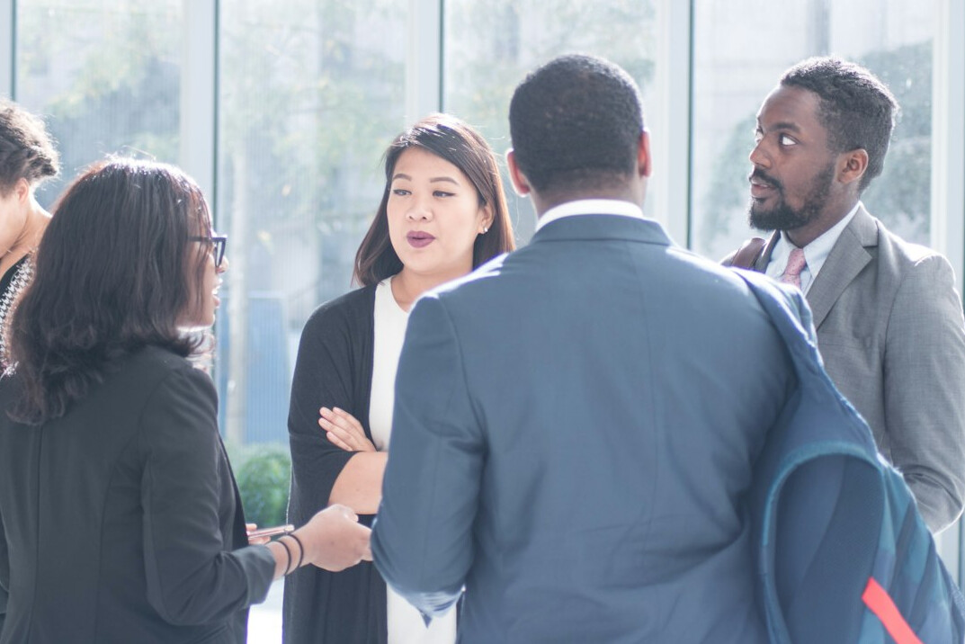 Colleagues in a meeting room discussing a project