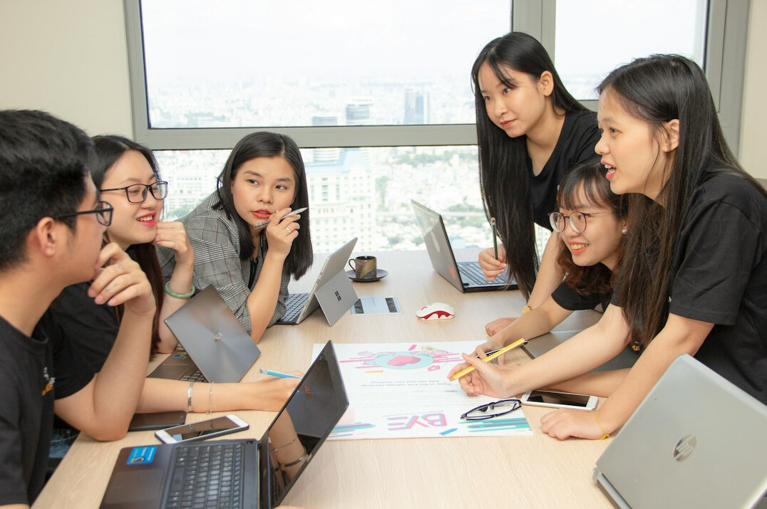 Team of colleagues collaborating around a laptop